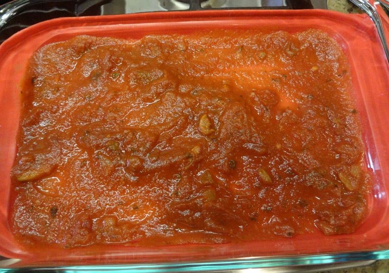 Spoon tomato sauce into the base of the dish.